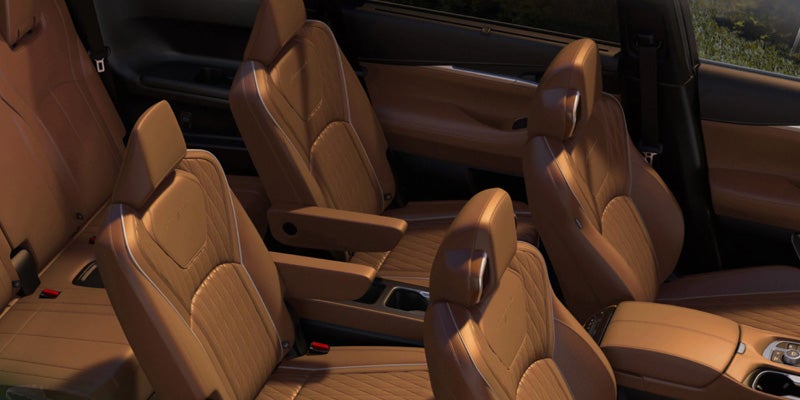 Interior view showing three rows of premium tan leather car seats