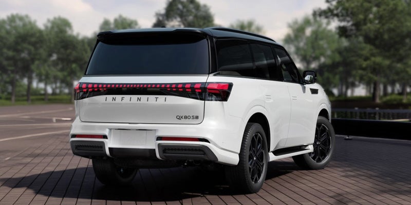 Rear view of a white Infiniti QX80 parked on a wooden deck.