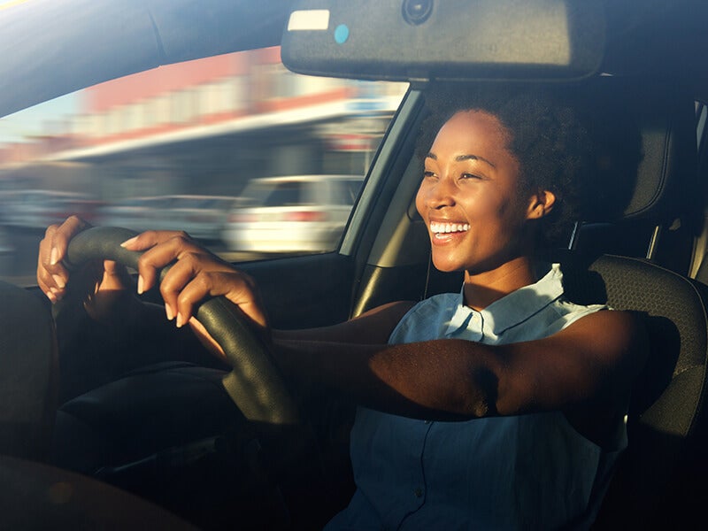 A person sits in the driver’s seat holding the steering wheel